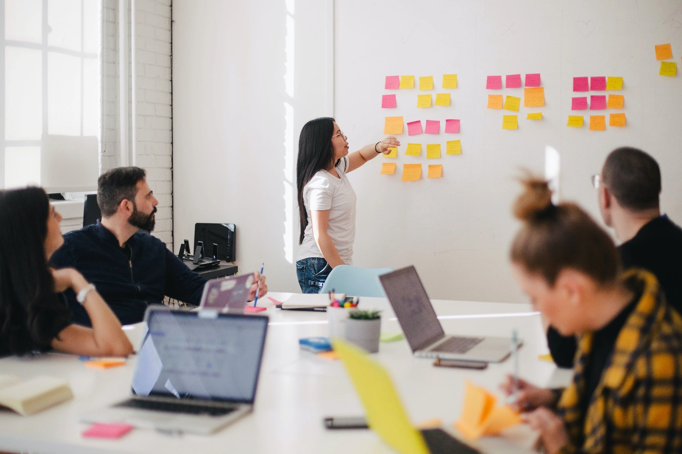 A group of people in a meeting room discuss a project